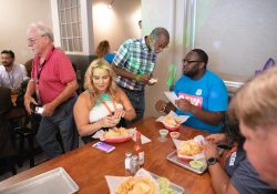 Julio 12, 2019: — Senator Art Haywood and and fellow legislators serve up food, coffee and drinks to customers during the busy happy hour at El Fuego restaurant in support of the federal Raise the Wage Act nationwide and One Fair Wage in the state.